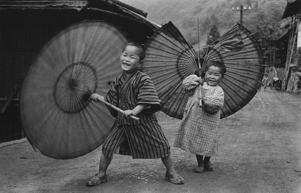 Domon Ken, Bambini che fanno roteare gli ombrelli, 1937 circa, dalla serie Bambini (Kodomotachi), Ogōchimura. Ken Domon Museum of Photography